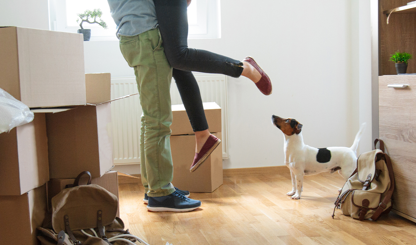 Happy man lifting woman in new house.