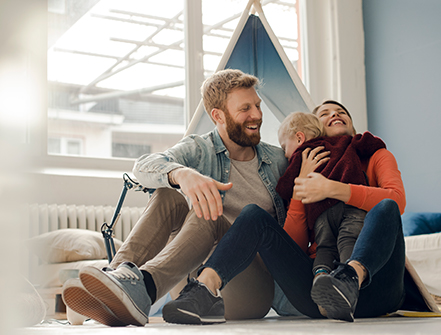Happy family playing with their son at home.